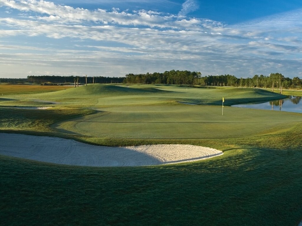 green flanked by a bunker on one side and water hazard on the other